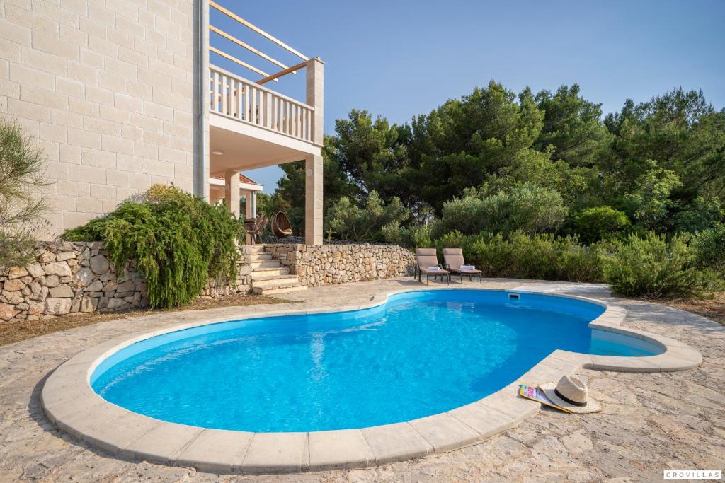 a swimming pool in front of a house at Milla Hvar in Rudina