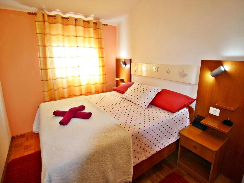 a bedroom with a bed with a red ribbon on it at AP Silvija in Zadar