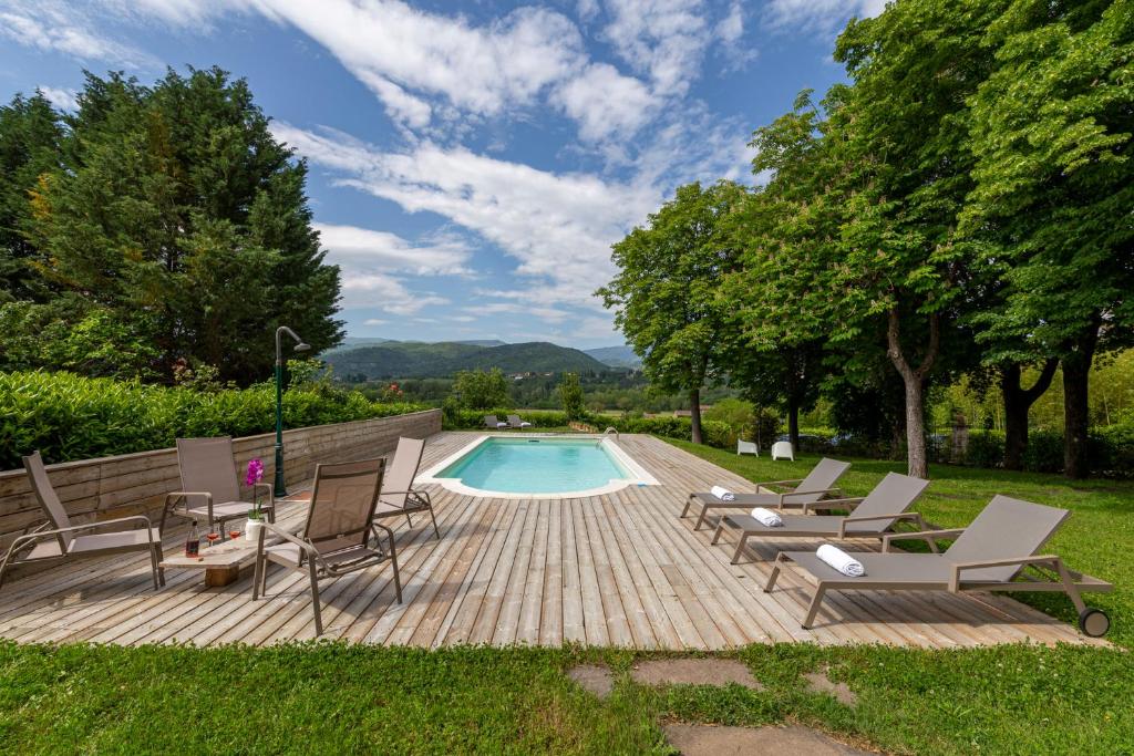eine Terrasse mit Stühlen und einem Pool in der Unterkunft L'Arboreto in Poppi