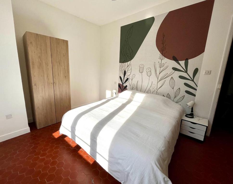 une chambre avec un lit blanc avec un tableau sur le mur dans l'établissement Superbe appartement centre-ville, à Ajaccio