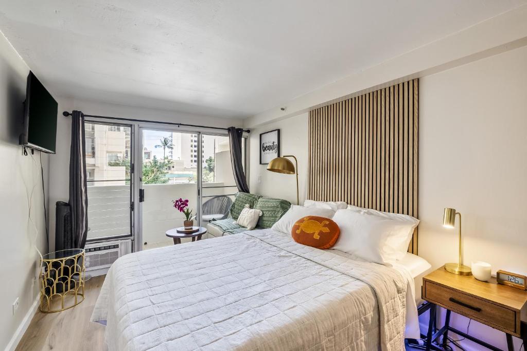 um quarto com uma grande cama branca e uma janela em Bright & Cozy Condo Unit with Balcony! em Honolulu