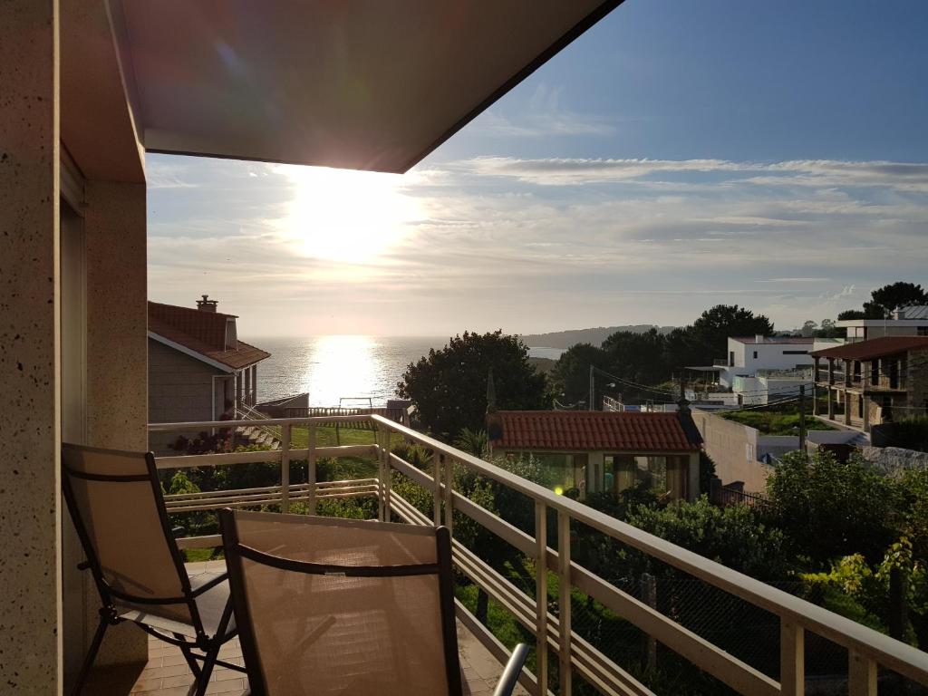 balcón con 2 sillas y vistas al océano en Casa Bascuas, en Portonovo