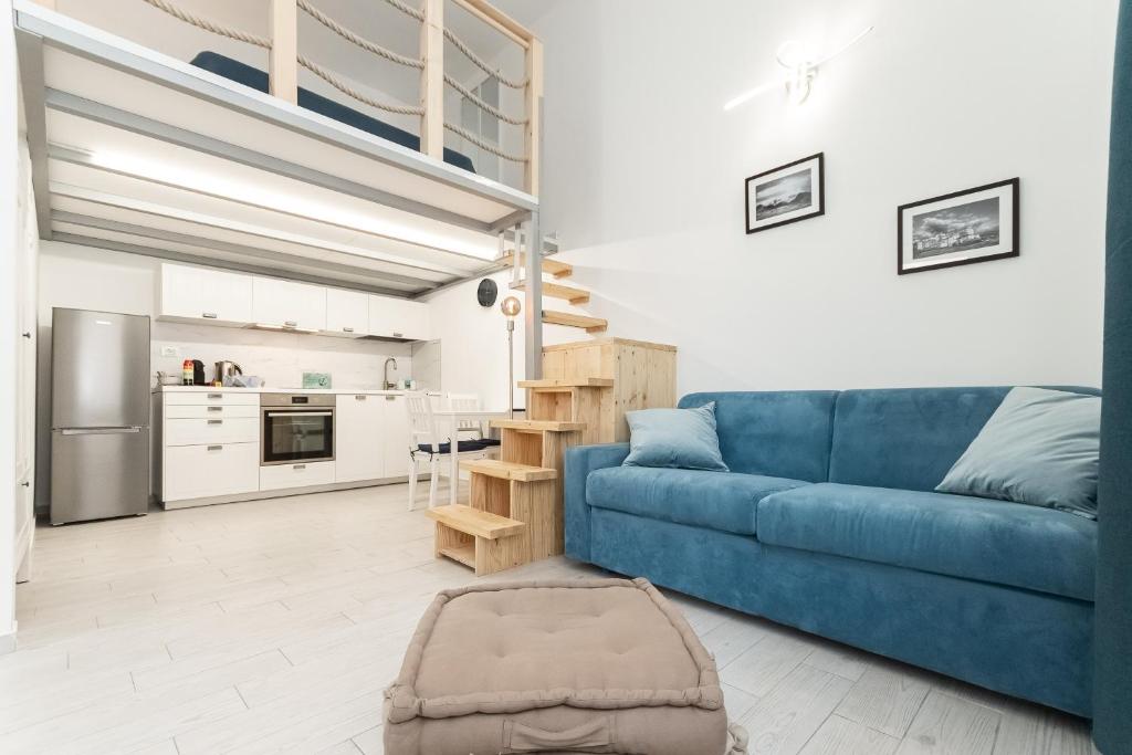 un soggiorno con divano blu e una cucina di Sea Loft Quinto - A due passi dal mare a Genova