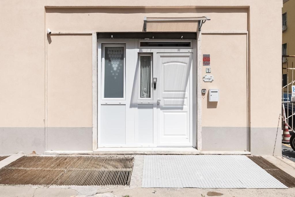 a white door on a building with a gate at Sea Loft Quinto - A due passi dal mare in Genoa