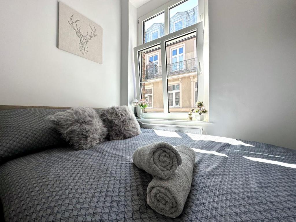a bedroom with a bed with pillows and a window at MMRent Wild Room in Gdańsk