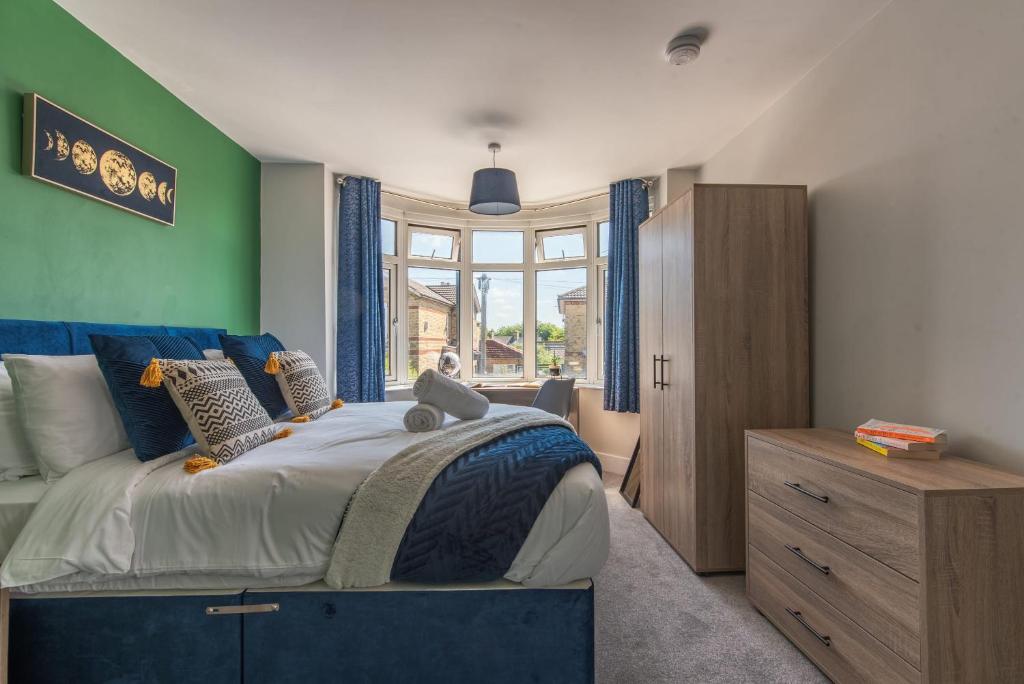 a bedroom with a bed and a green wall at Spacious Southampton House Sanctuary in the City in Southampton