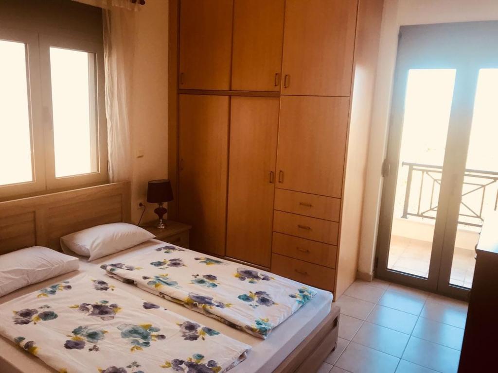 een slaapkamer met een bed, een kast en een raam bij Eleni's Apartments in Agios Nikolaos