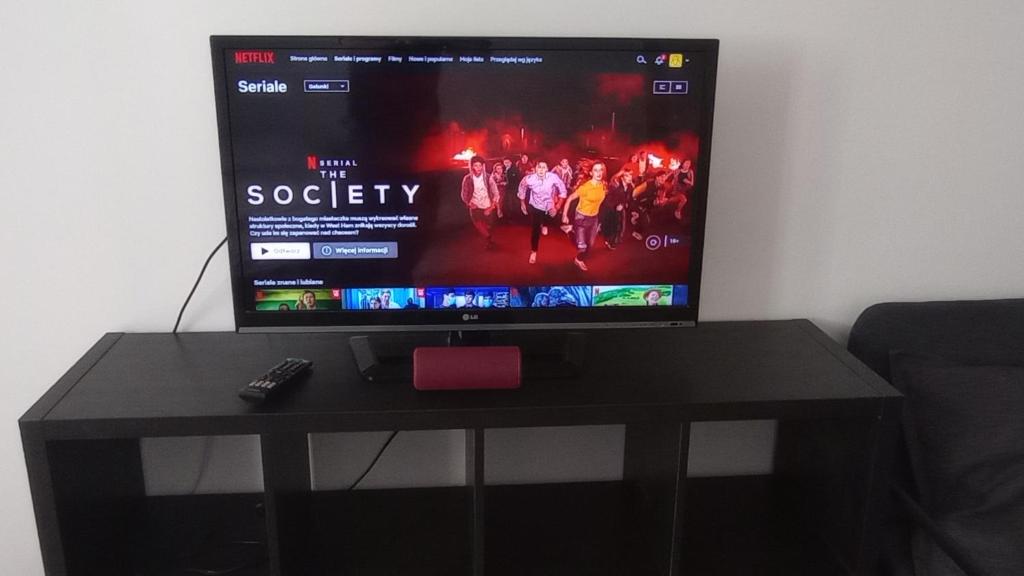 a flat screen tv sitting on a black table at SELF CHECK-IN APARTAMENT LOTNISKO SZPITAL PARKING TARGi in Poznań