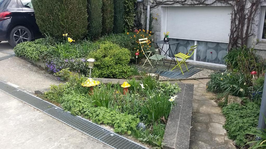 a garden with flowers and plants on a street at Les Nympheas, appart, grand jardin au calme, parking gratuit,15 min Disneyland, in Crécy-la-Chapelle