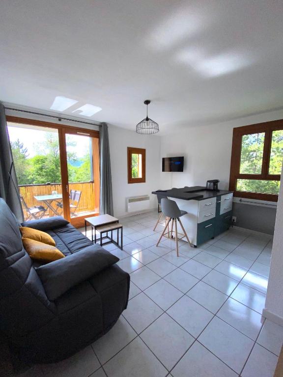 un salon avec un canapé et une table dans l'établissement Appartement situé à coté du Lac de Serre Ponçon, à Saint-Sauveur