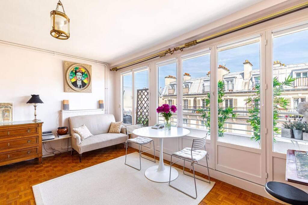 a living room with a table and chairs and a window at GuestReady - Midsummer bloom in the 12th Arr. in Paris