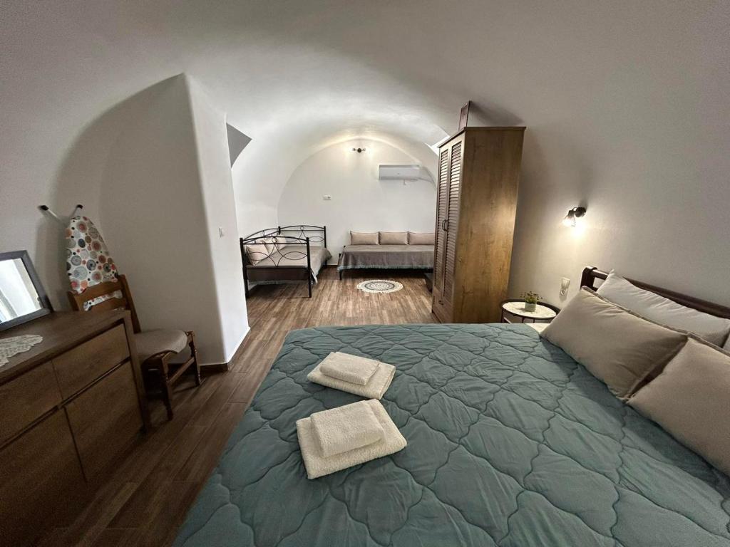 1 dormitorio con 1 cama grande y 2 toallas. en Nikolas House - ΤΟ ΣΠΙΤΙ ΤΟΥ ΝΙΚΟΛΑ en Archea Pissa