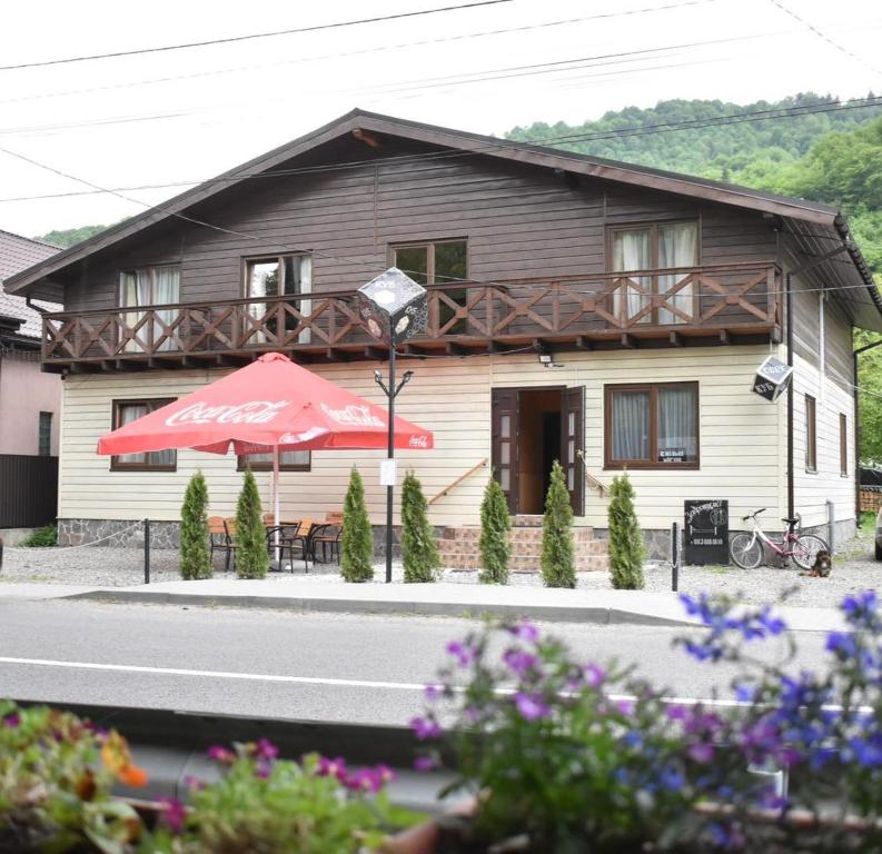 una casa con un ombrello rosso davanti di Cube a Kvasy