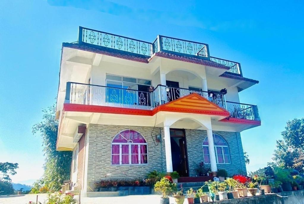 a house with a balcony on top of it at Aroma Homestay in Kalimpong