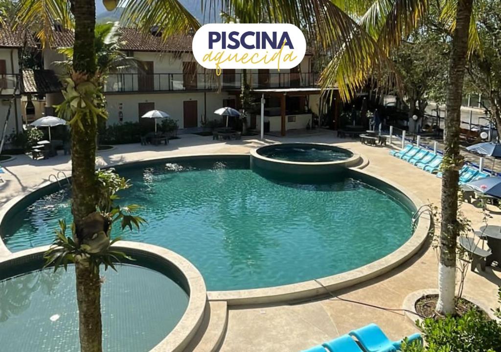 a swimming pool in a resort with palm trees at Pousada Ilha Vitoria in Ubatuba