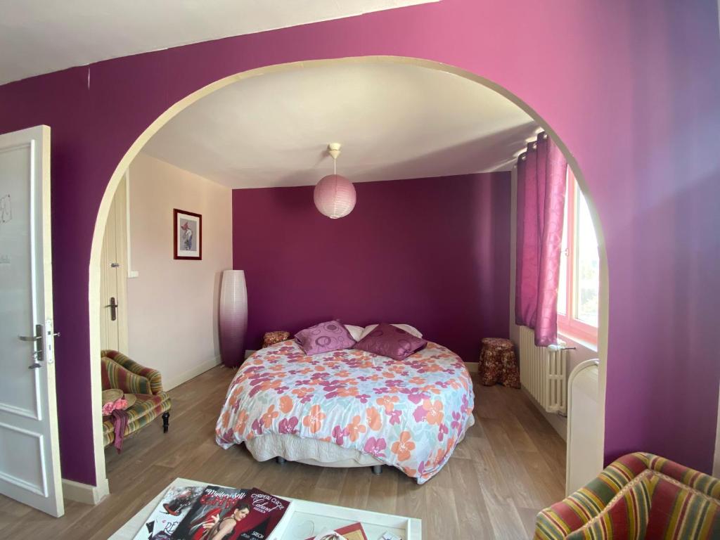a bedroom with purple walls and a large bed at Chambres d’hôte au Chapeau Claque Cabaret in Gueugnon