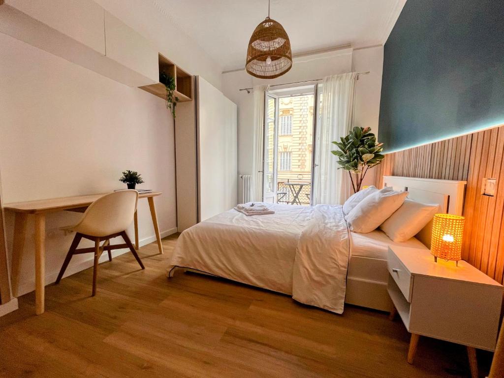 a bedroom with a bed and a desk and a table at Sunshine Getaway - Stylish Studio in the Heart of Nice in Nice