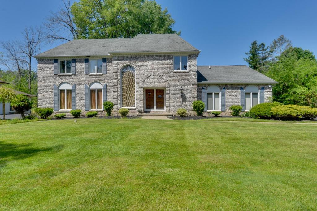 a stone house with a large grass yard at Spacious Buffalo Brick Home w/ Backyard! in Buffalo