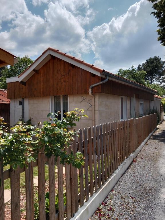 une clôture en bois devant une maison dans l'établissement Maison de charme, à Audenge