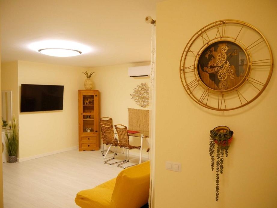 un soggiorno con divano giallo e TV di Apartamento Guadiana Sol a Estepona