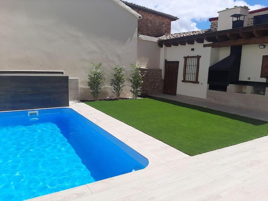 a swimming pool in a yard next to a house at Casa Rural Triticum 