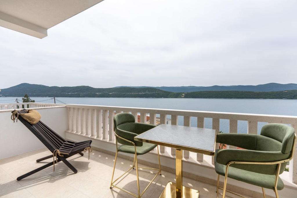 - un balcon avec des chaises, une table et de l'eau dans l'établissement Villa Emina sa privatnom Plažom i Parkingom, à Neum