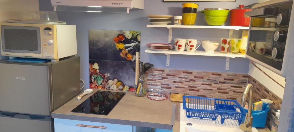 une cuisine avec un réfrigérateur et un plan de travail dans l'établissement Locations IDEALOGIS Studios et T2 avec WIFI LAVERIE VELOS, à Rochefort