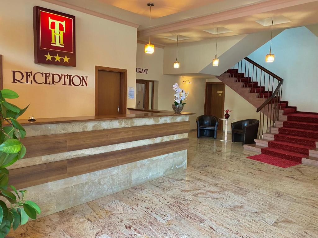 vestíbulo de un hotel con escaleras y recepción en Hotel Termal, en Geoagiu Băi