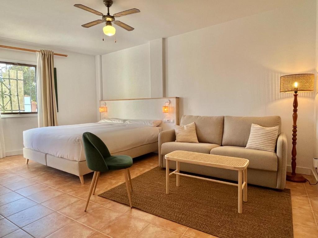 ein Schlafzimmer mit einem Bett und einer Couch in der Unterkunft Casa La Aguanosa con piscina y vistas al mar in Frigiliana