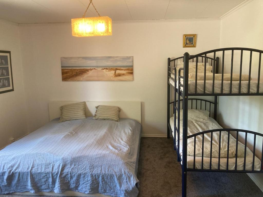 a bedroom with two bunk beds and a ladder at Björklunden in Gullringen
