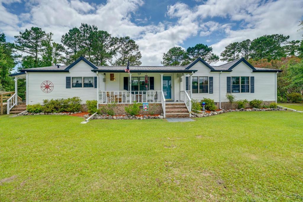 a white house with a lawn in front of it at Secluded Hampstead Vacation Rental with Deck! in Surf City