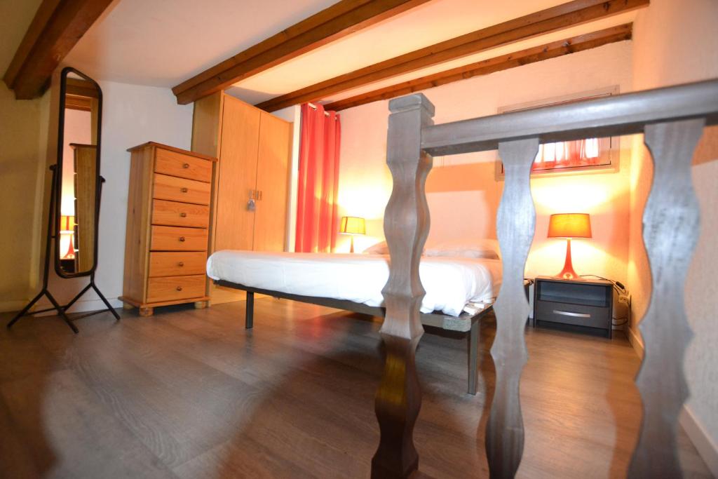 een slaapkamer met een bed en een dressoir bij Villa Naturiste "EDEN" Héliovillage 105 in Cap d'Agde