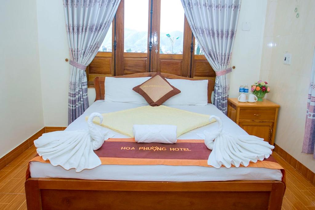 a bedroom with a large bed with a wooden headboard at HOA PHUONG PHONG NHA Hotel in Phong Nha