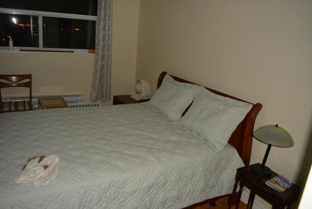 1 dormitorio con 1 cama blanca y ventana en Penthouse on the Lake, en Burlington