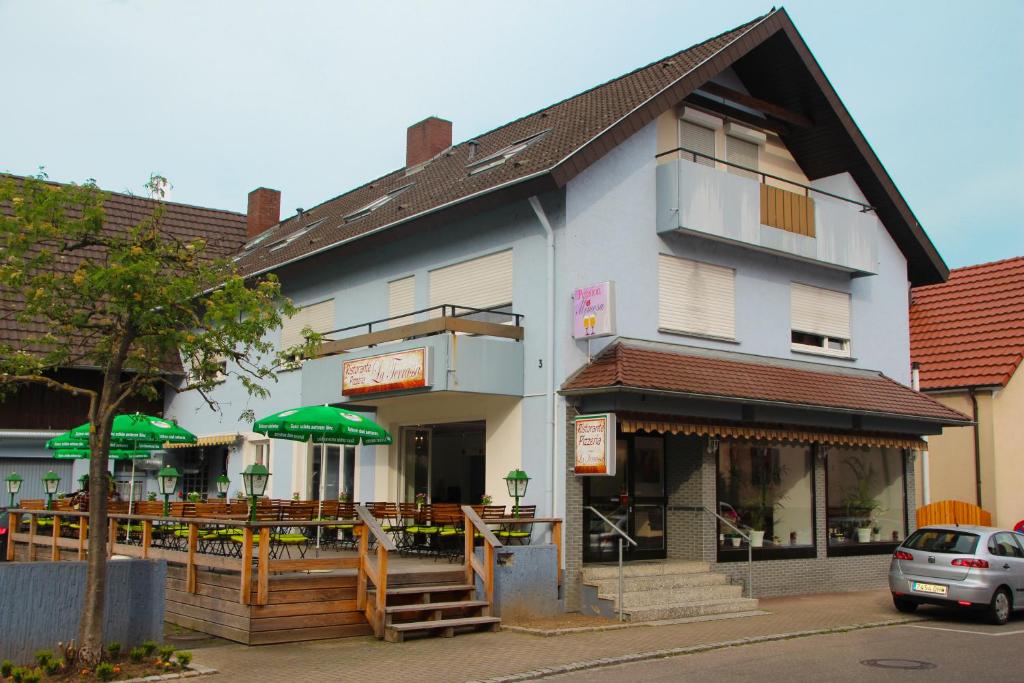 a building with a restaurant with green umbrellas at Pension Mimosa in Rust