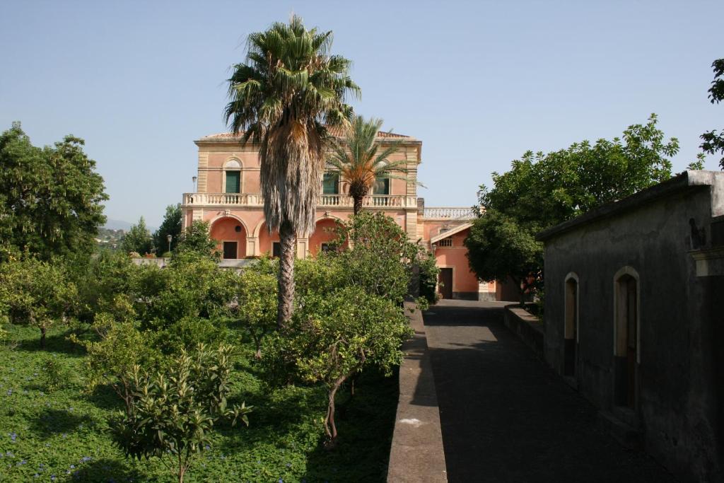 a house with a palm tree in front of it at Villa dei leoni in Santa Tecla