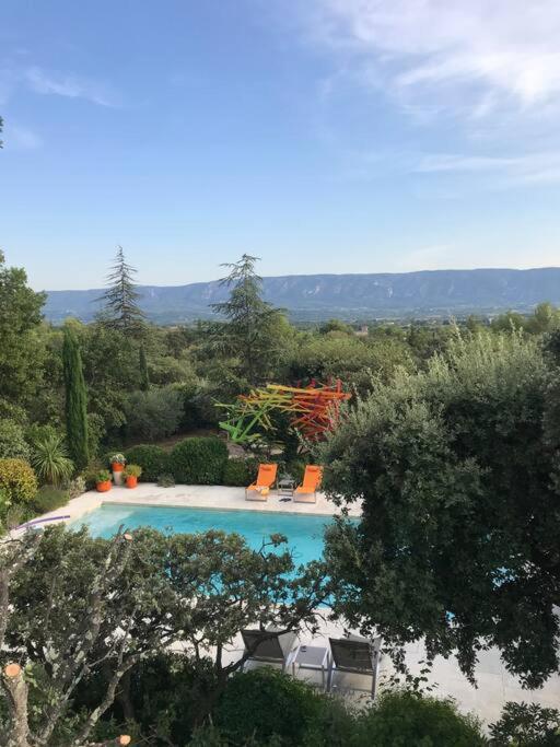 - une vue sur la piscine bordée de chaises et d'arbres dans l'établissement Villa de vacances familiale avec jardin et piscine, à Cabrières-dʼAvignon