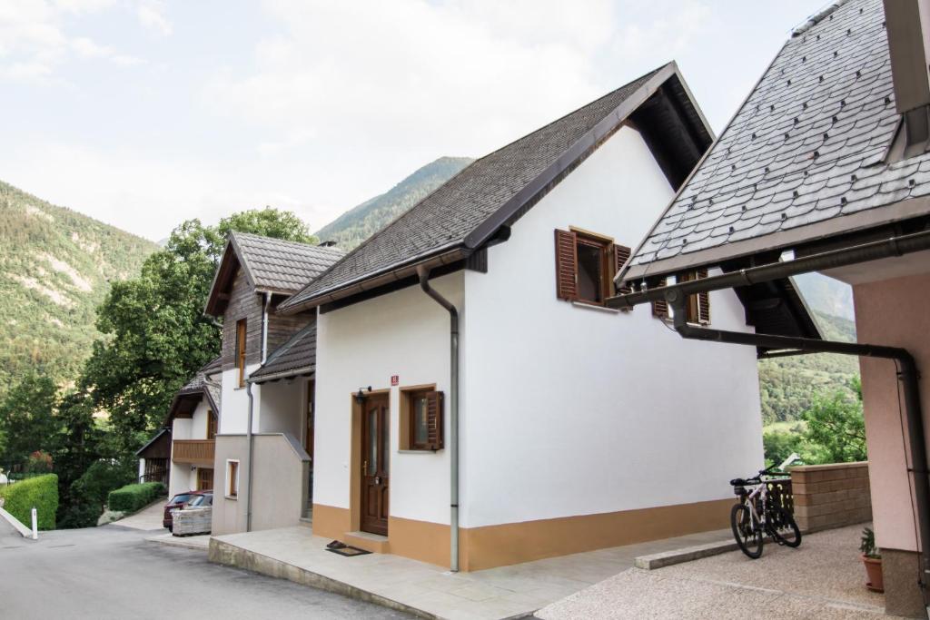 ein weißes Haus mit schwarzem Dach in der Unterkunft Apartma Lojz in Bovec