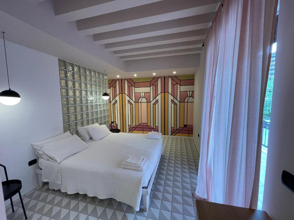1 dormitorio con cama blanca y ventana en Dusmè, en Taranto
