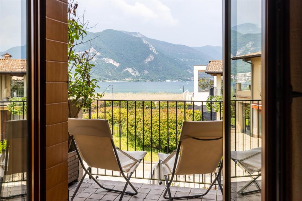 a balcony with two chairs and a view of the ocean at IseoLakeRental - Casa Giovannina in Paratico