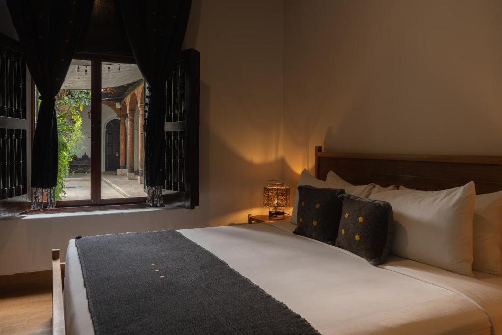 a bedroom with a large bed with a window at Sombra del Agua in San Cristóbal de Las Casas