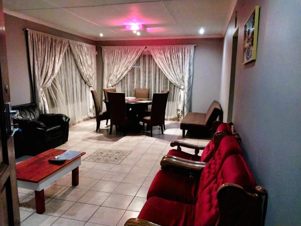 un soggiorno con divano e tavolo di East-Coast Guesthouse: Serene, Private, Secure a Durban