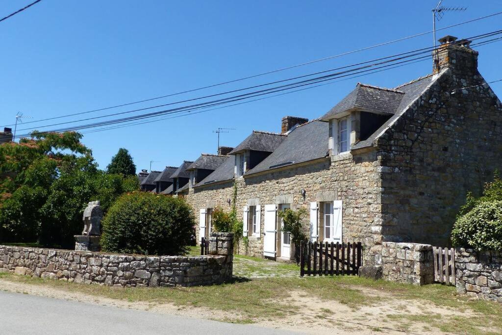 ein altes Steinhaus mit einer Steinmauer in der Unterkunft Crac’h, grande maison de vacances au calme in Crach