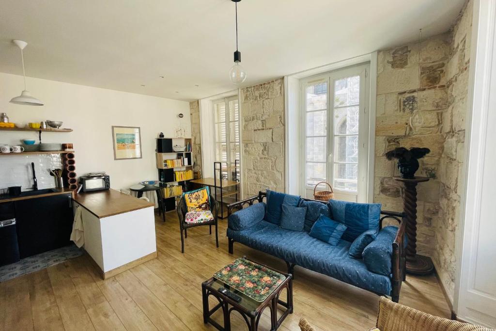 ein Wohnzimmer mit einem blauen Sofa und einer Steinmauer in der Unterkunft Corner cocoon in the center of La Rochelle in La Rochelle
