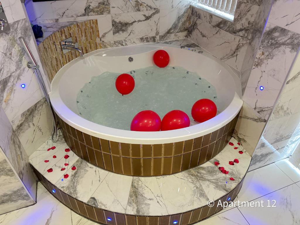 a bath tub with four cherries in the water at Mansa Apartments in Bradford