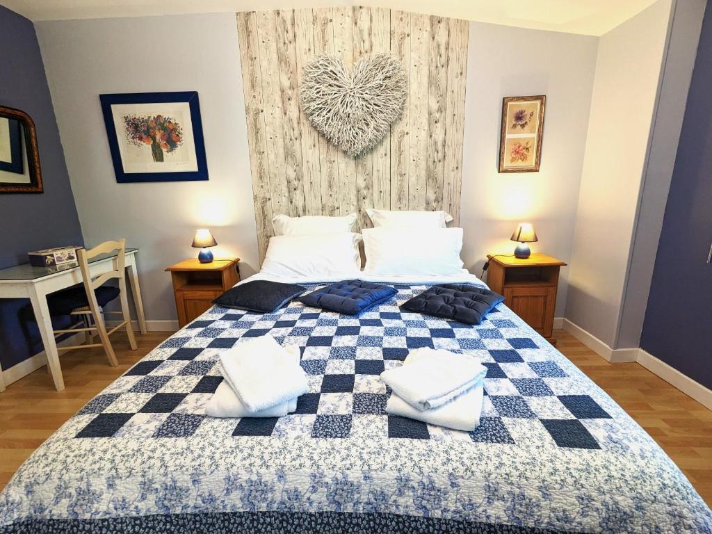 - une chambre avec un lit doté d'une couverture en damier bleu et blanc dans l'établissement La Borie du Chevrier, à Sainte-Croix-de-Beaumont