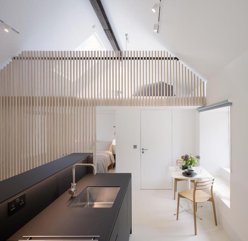 uma cozinha com um lavatório e uma mesa em Eastside - Architect designed retreat with wood-fired sauna em Penicuik