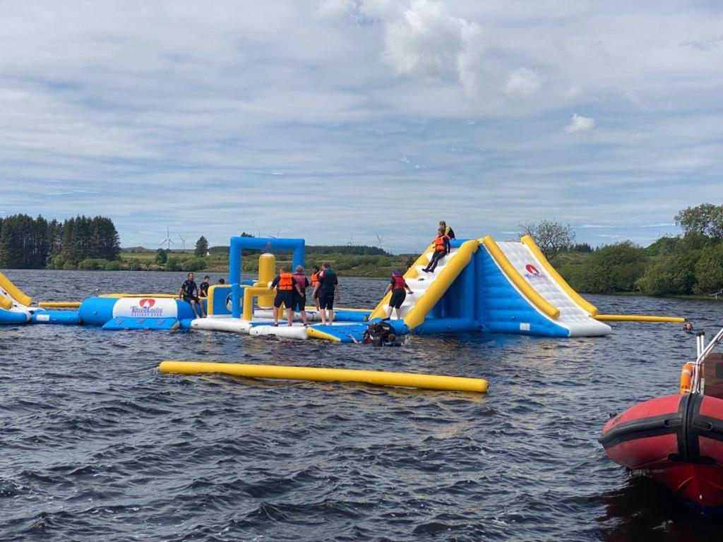 a group of people playing on an inflatable slide in the water at 57 Peaceful Corner Caravan in Balminnoch