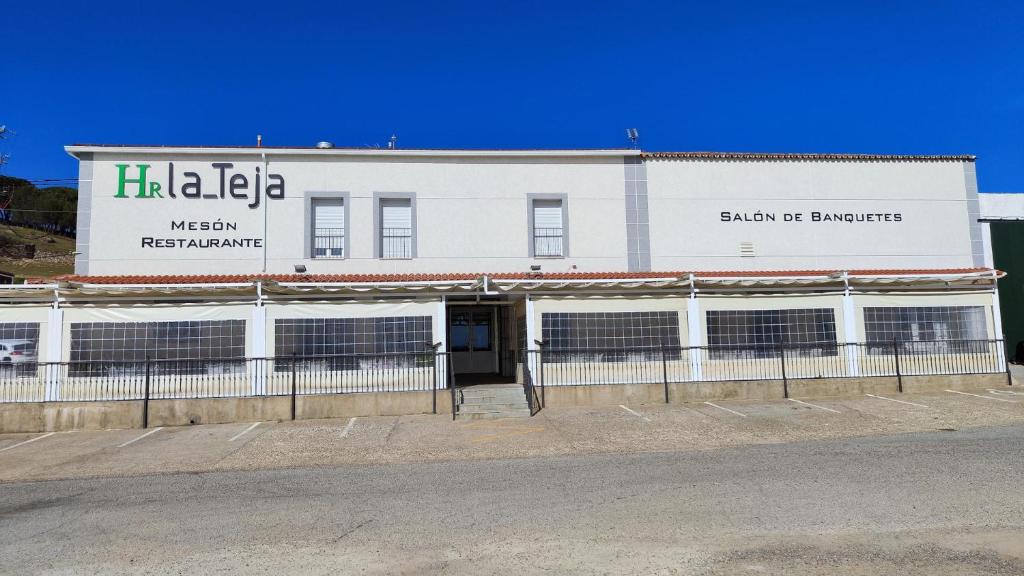 un gran edificio blanco con un cartel. en HOTEL RURAL LA TEJA, en Segura de León