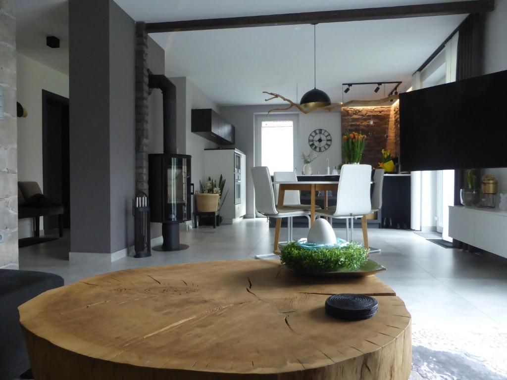 a living room with a wooden table and a dining room at Apartament Premium Moszna in Moszna